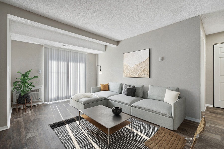 Model Living Room with Wood-Style Flooring and Patio Accessibility at Liberty Creek Apartments in Aurora, CO.