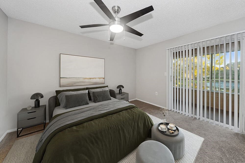 Model Bedroom with Carpet and Patio Accessibility at Walden Lake Apartments in Plant City, FL.
