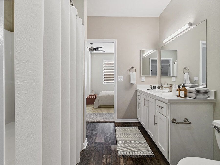 Model Bathroom with White Cabinets, Wood-Style Flooring & Shower/Tub at Reserve at Rancho Apartments located in Moreno Valley, CA.