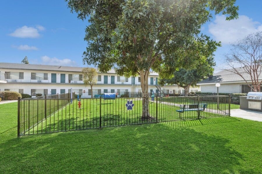 Community Dog Park with Grass, a Fence, & Agility Equipment at Forest Park Apartments in El Cajon, CA.