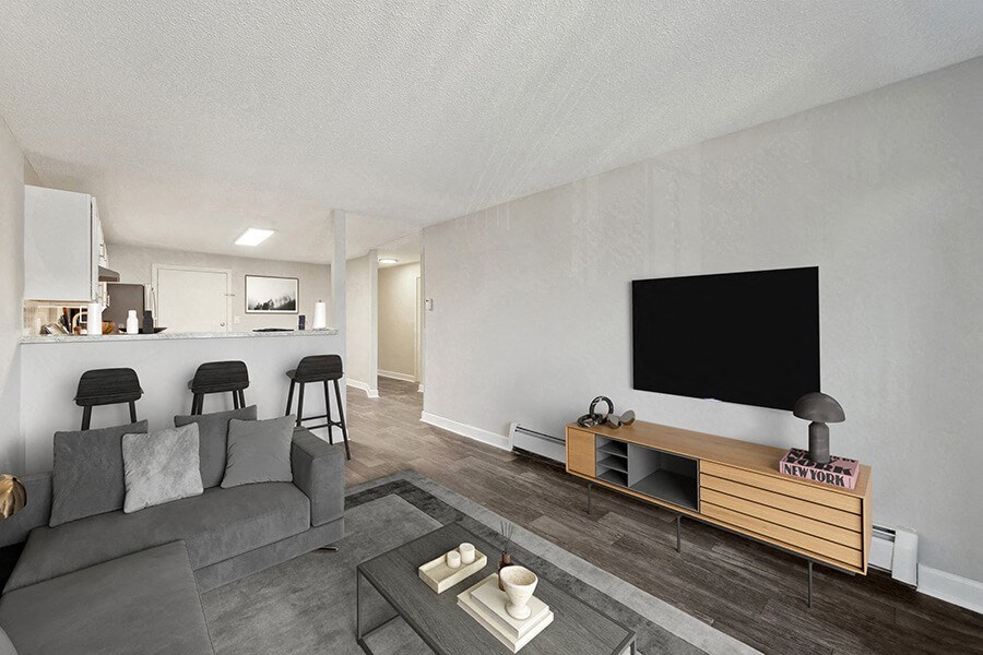 Model Living Room with Wood-Style Flooring and View of Kitchen at Middlesex Crossing Apartments in Billerica, MA.