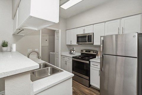 a kitchen with stainless steel appliances and white cabinets