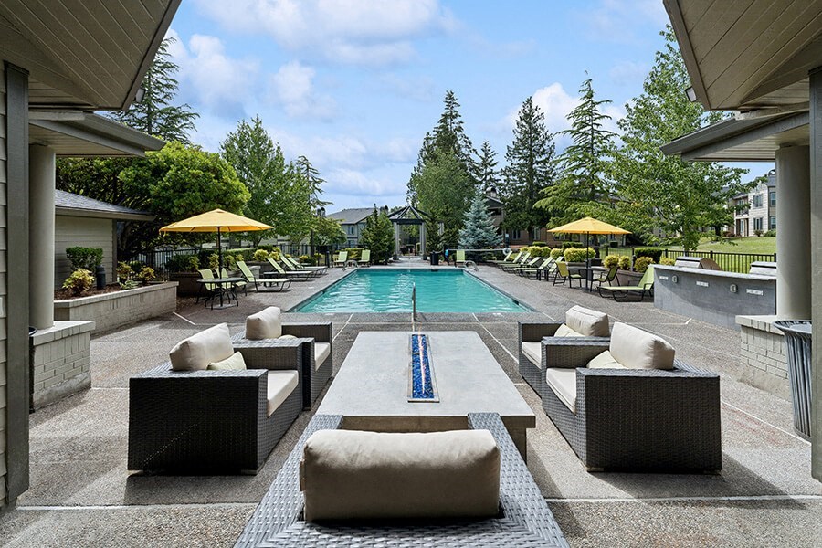 Community Swimming Pool with Lounge Furniture at The Club Apartments located in Hillsboro, OR.