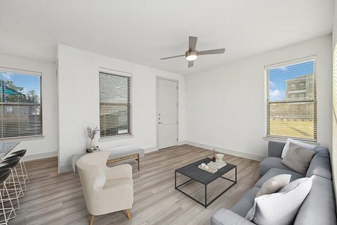 Model Living Room with Wood-Style Flooring and Patio Accessibility at Alta 3Eighty Apartments located in Aubrey, TX.