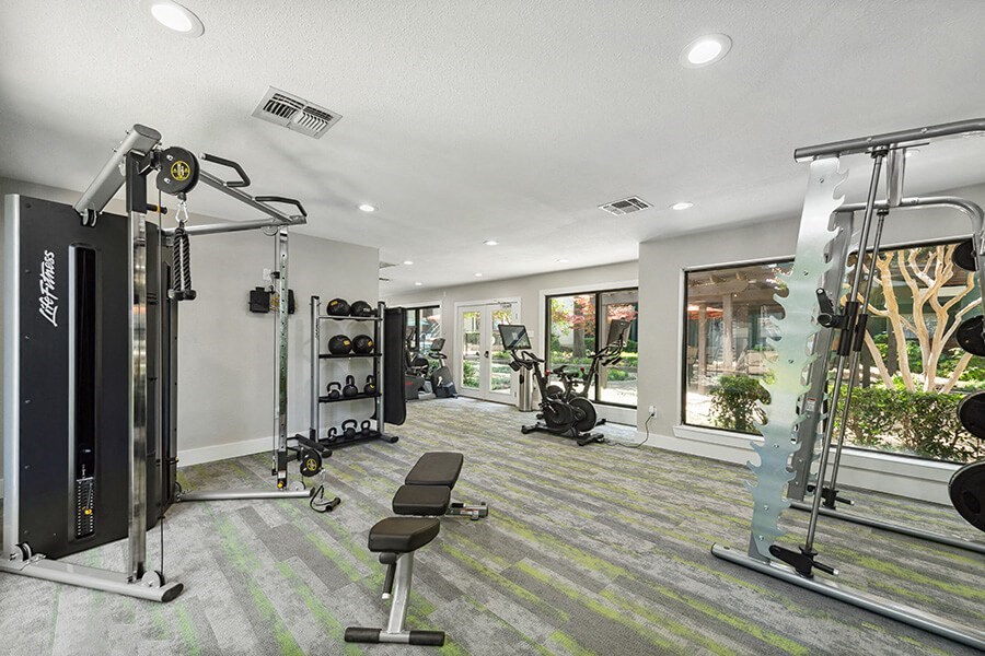 Community Fitness Center with Equipment at Bridges at Deer Run Apartments in Dallas, TX.