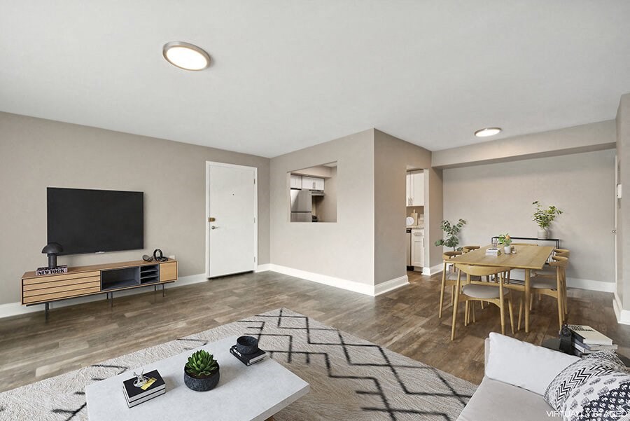 Model Living Room with Wood-Style Flooring and View of Kitchen/Dining Area at Heights at Marlborough Apartments located in Marlborough, MA.