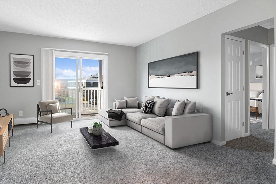 Model Living Room with Carpet and Patio Accessibility at Stone Ends Apartments in Stoughton, MA.