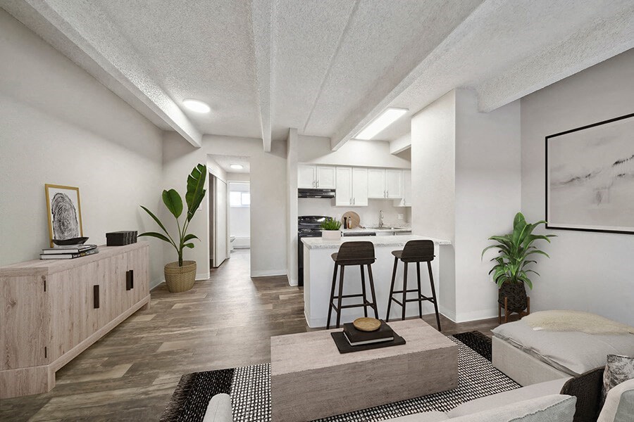 Model Living Room with Wood-Style Flooring and View of Kitchen at Esprit at Cherry Creek Apartments in Glendale, CO.