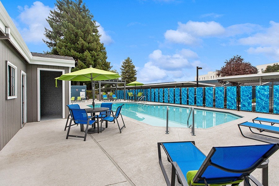 Community Swimming Pool with Pool Furniture at Meritage Apartments in Vallejo, CA.