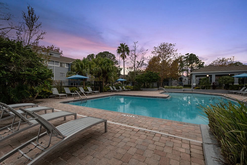Community Swimming Pool with Pool Furniture at Westland Park Apartments in Jacksonville, FL.