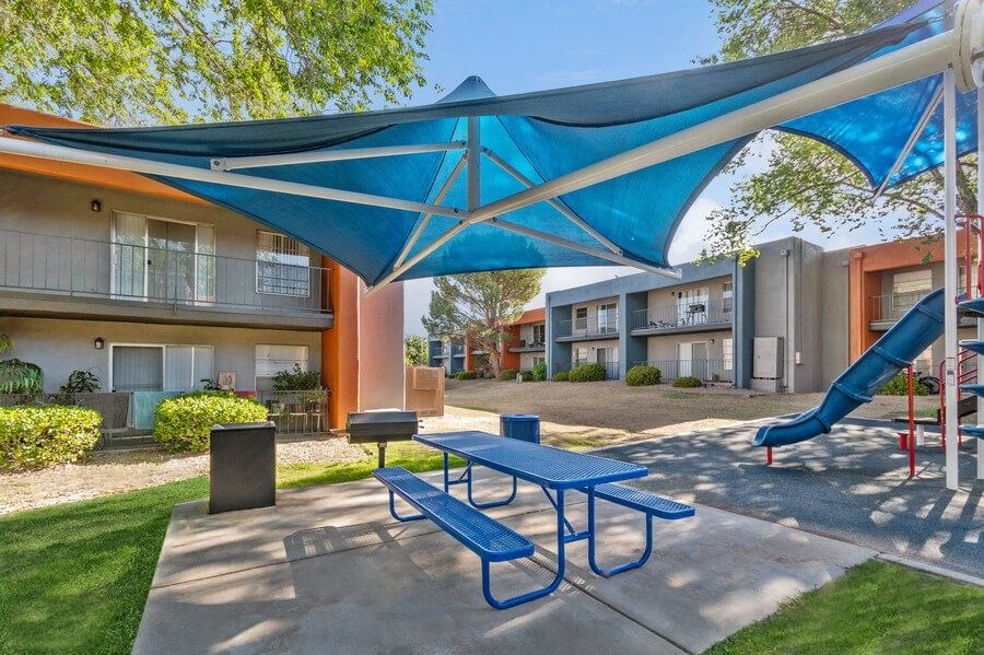 Outdoor BBQ Area with Blue Canopy and Picnic Table at Indigo Park Apartments in Albuquerque, NM.