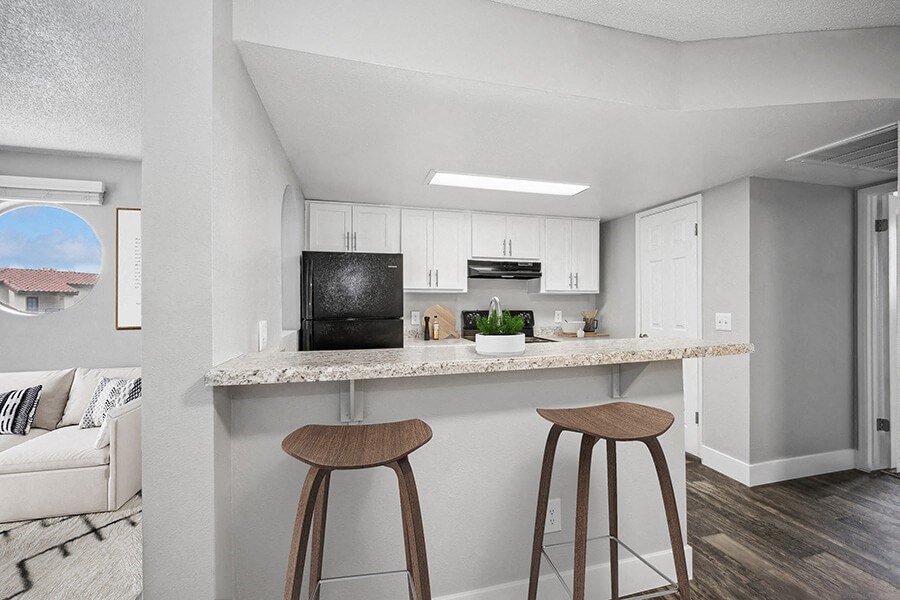 Model Kitchen with White Cabinets and Wood-Style Flooring at Stillwater Apartments located in Glendale, AZ.