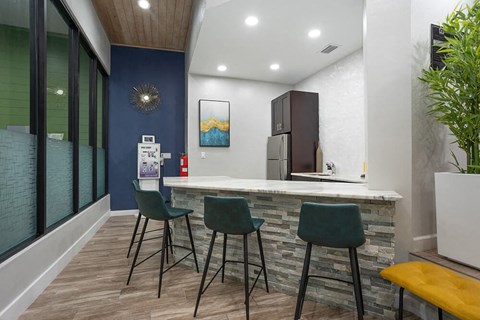a kitchen with a counter and three chairs