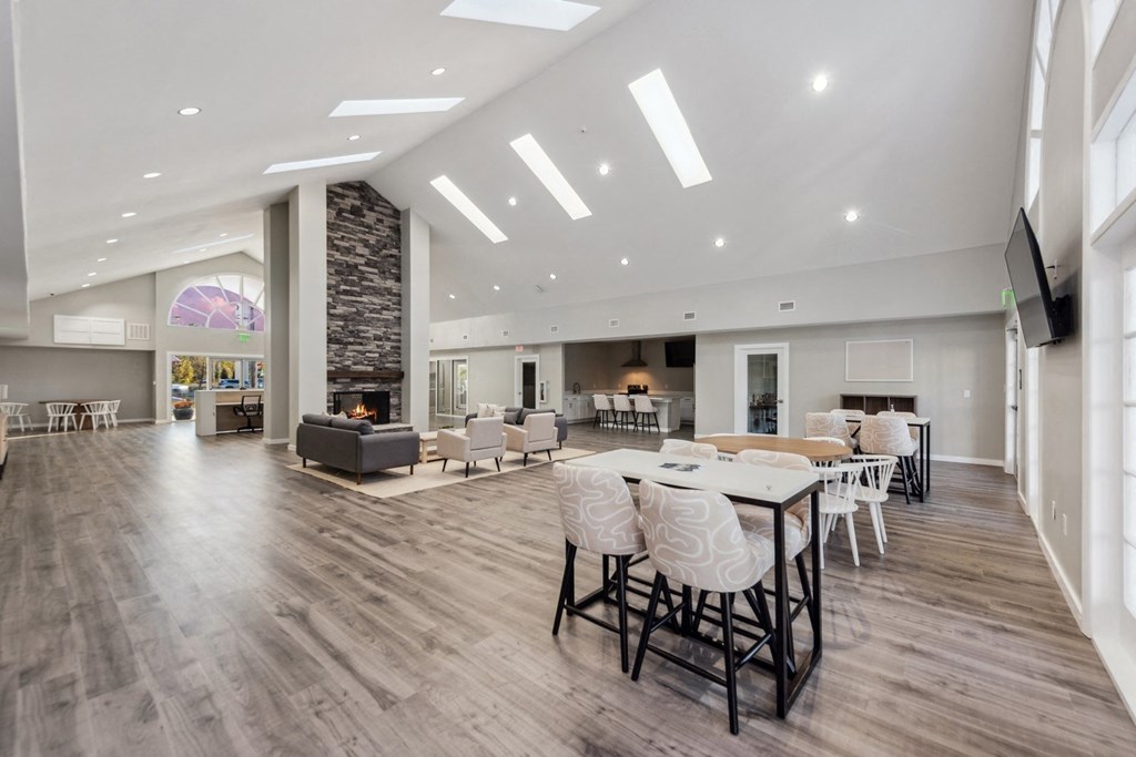 a large living room with a table and chairs and a fireplace