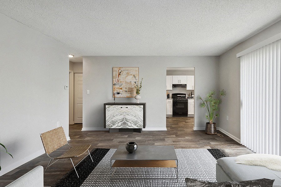 Model Living Room with Wood-Style Flooring and View of Kitchen at Parc at Creekside Apartments in Kansas City, MO.