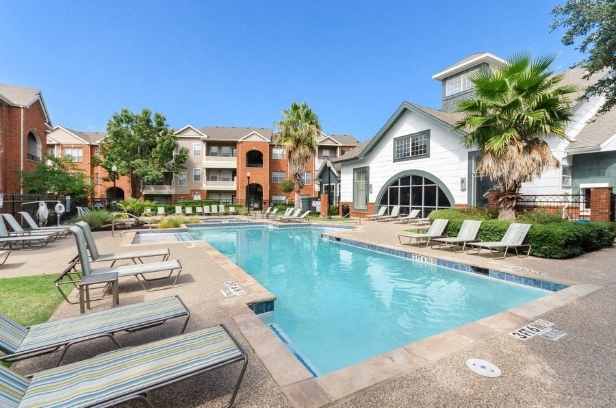 Resort style swimming pool next to clubhouse and apartment buildings