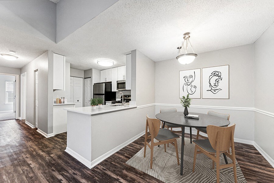 Model Dining Room with Wood-Style Flooring and View of Kitchen at Commons at Haynes Farm Apartments in Shrewsbury, MA.