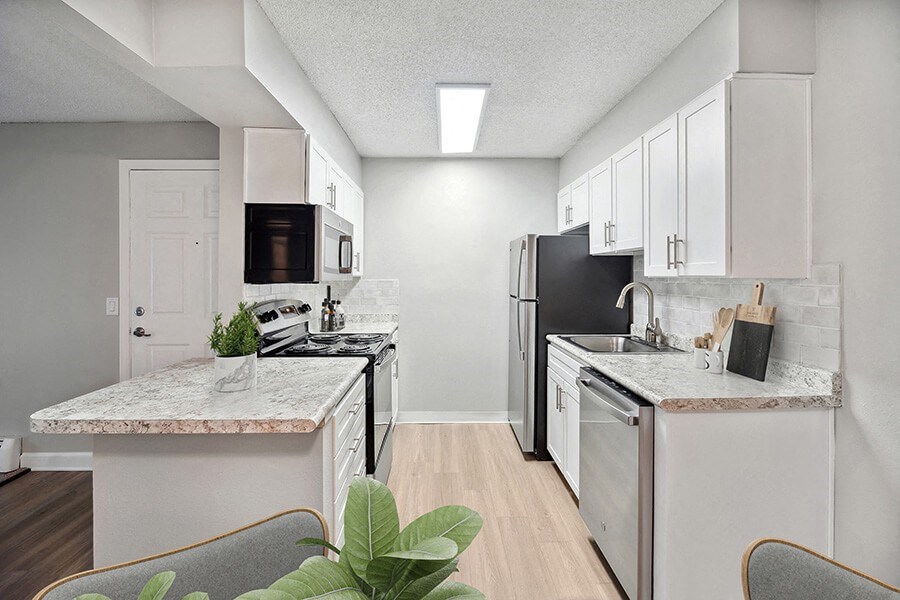Model Kitchen with White Cabinets and Wood-Style Flooring at Waterfront Apartments in Lakewood, CO.