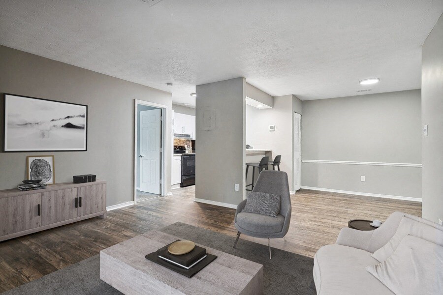 living room and dining room of an apartment with a couch and chairs