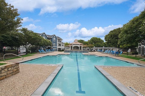 Community Swimming Pool with Pool Furniture at Hidden Creek Apartments located in Lewisville, TX.
