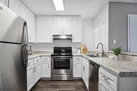 a kitchen with white cabinets and stainless steel appliances