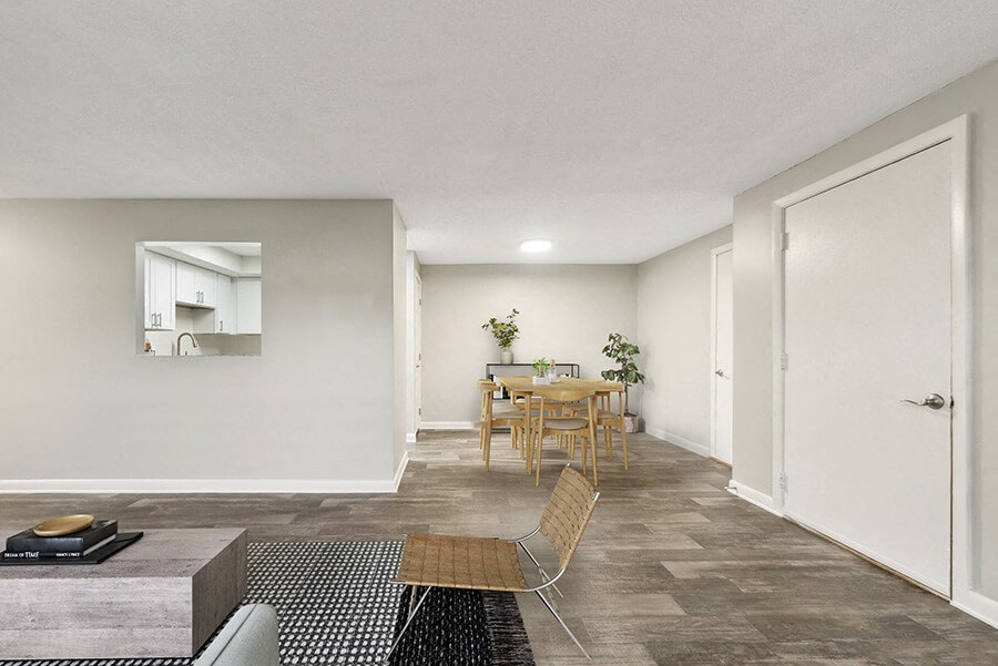 Model Living Room with Wood-Style Flooring and View of Dining Room at Meadows at Marlborough Apartments located in Marlborough, MA.