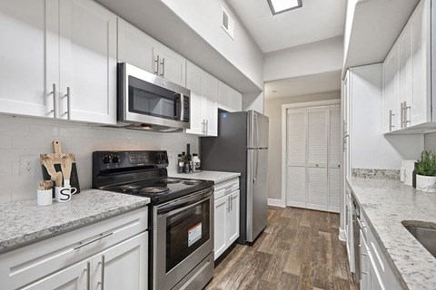 a kitchen with stainless steel appliances and white cabinets