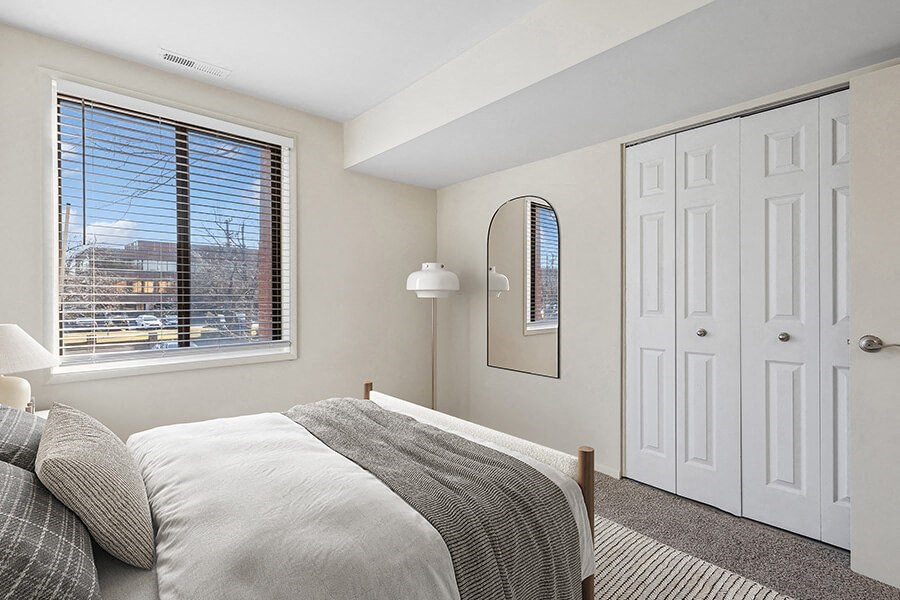 Model Bedroom with Carpet and Window View at Spring Parc Apartments in Silver Spring, MD.