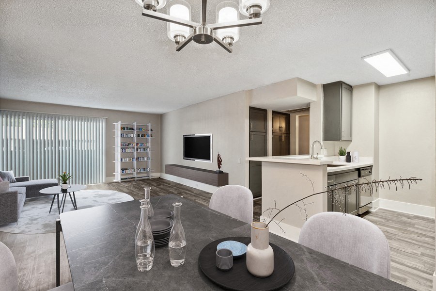 Model dining area with view of living room and kitchen