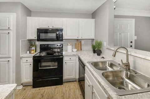 a kitchen with black appliances and white cabinets