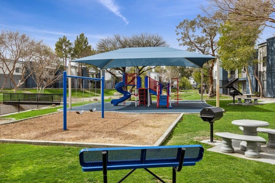 a playground with a slide and picnic table