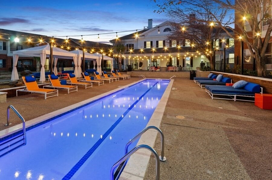 Very long swimming pool with cabanas and chairs