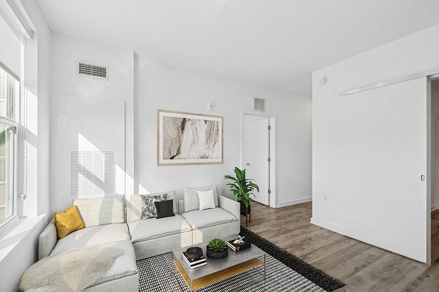 Model Living Room with Wood-Style Flooring and Window View at Stella Apartments located in New Carrollton, MD.