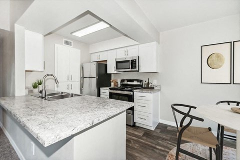 a white kitchen with a marble counter top
