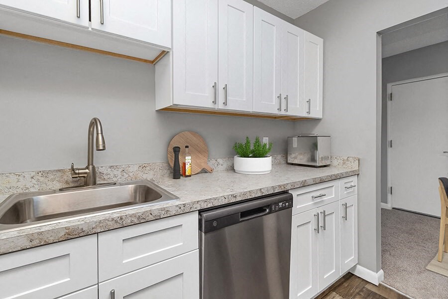 Model Kitchen with White Cabinets and Wood-Style Flooring at Stone Ends Apartments in Stoughton, MA.