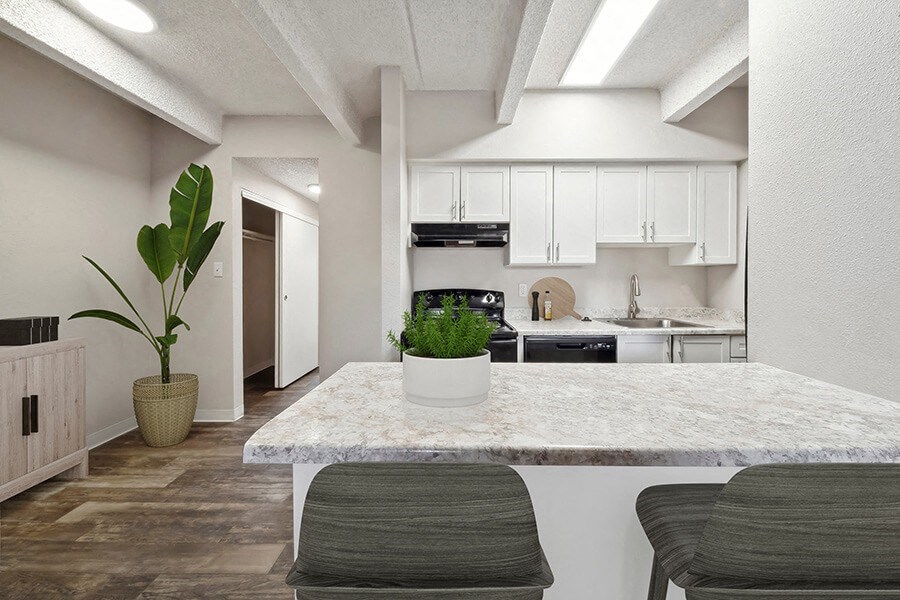 Model Kitchen with White Cabinets and Wood-Style Flooring at Esprit at Cherry Creek Apartments in Glendale, CO.