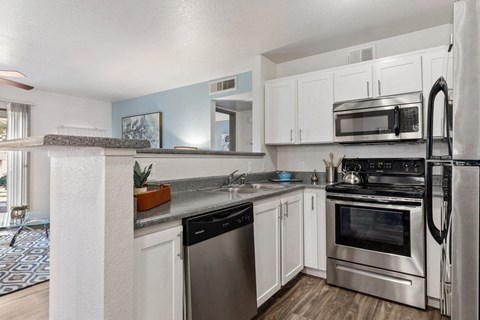 a kitchen with stainless steel appliances and white cabinets