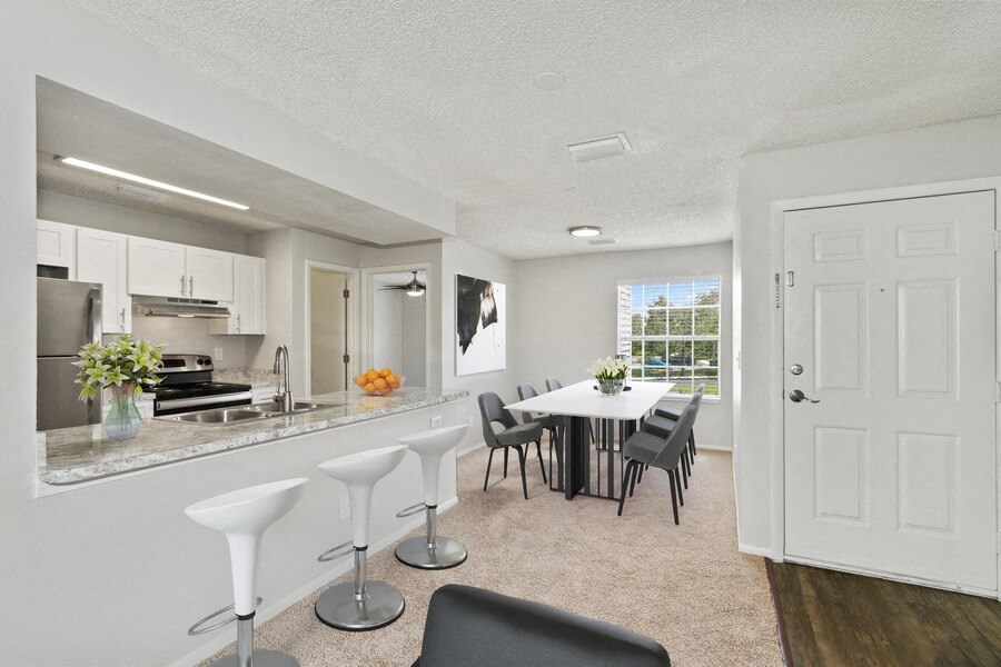 Model kitchen with bar seating and dining room