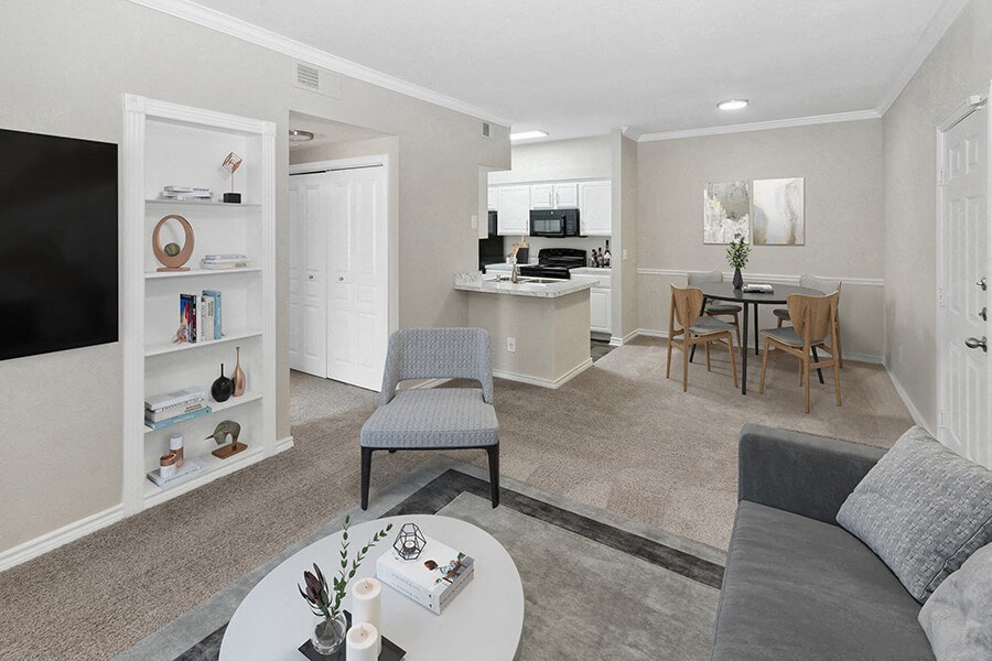 Model Living Room and Dining Room Area with Carpet at Belmont at Duck Creek Apartments in Garland, TX.