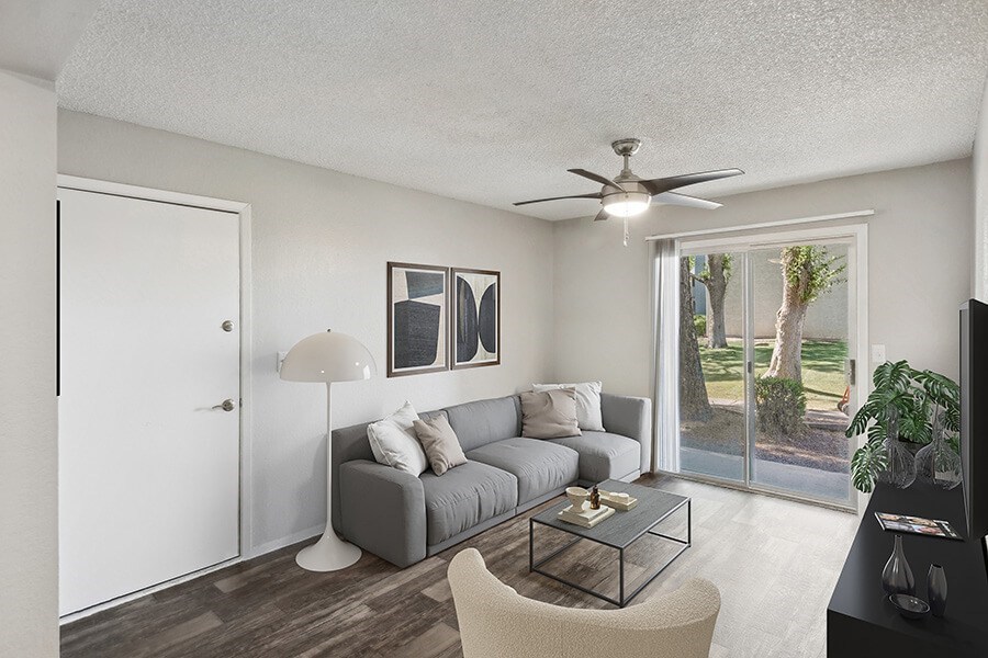 Model Living Room with Wood-Style Flooring and Patio Accessibility at Solano Springs Apartments located in Tucson, AZ.