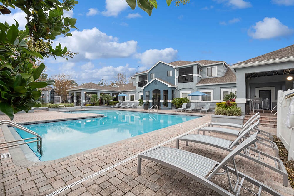 Community Swimming Pool with Pool Furniture at Westland Park Apartments in Jacksonville, FL.