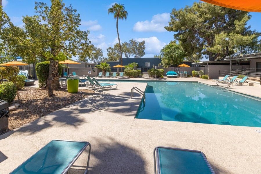 Community Swimming Pool with Pool Furniture at Lakeside Casitas Apartments in Tucson, AZ.