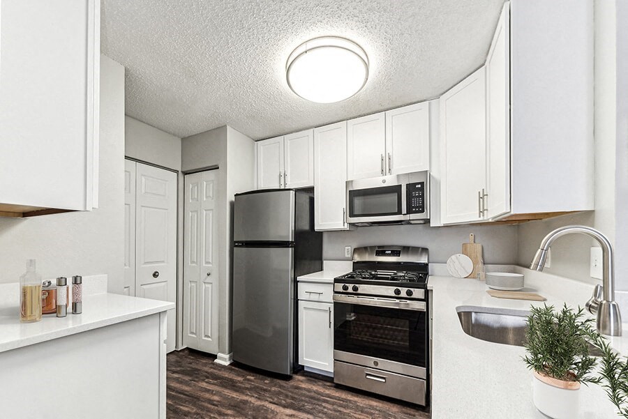 Model Kitchen with White Cabinets and Wood-Style Flooring at Commons at Haynes Farm Apartments in Shrewsbury, MA.