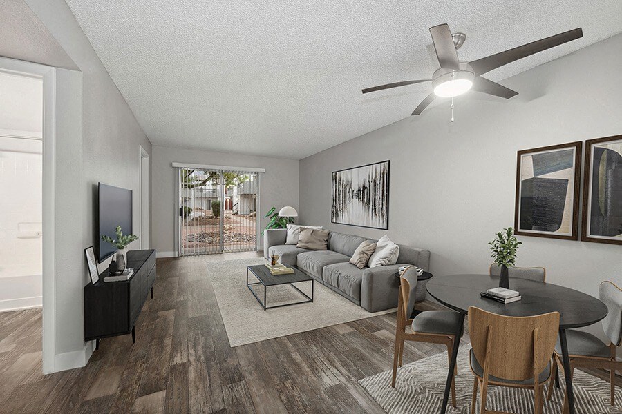 Model Living Room with Wood-Style Flooring and Patio Accessibility at Crystal Creek Apartments located in Phoenix, AZ.