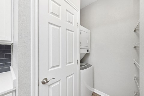 Model Laundry Room with Washer & Dryer at Hidden Creek Apartments located in Lewisville, TX.