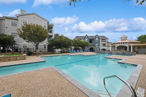 Community Swimming Pool with Pool Furniture at Hidden Creek Apartments located in Lewisville, TX.