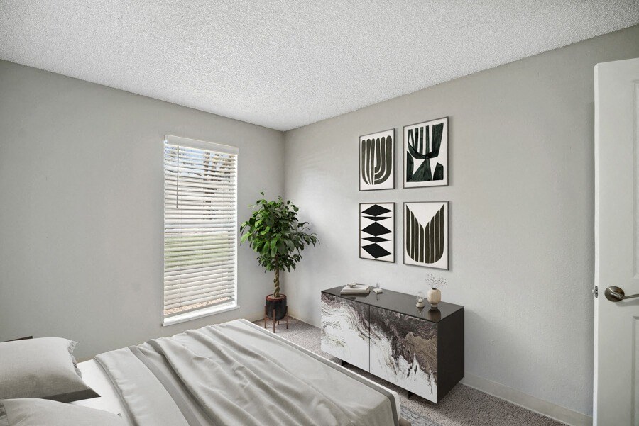 a bedroom with a bed and a dresser in front of a window