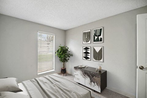 a bedroom with a bed and a dresser in front of a window