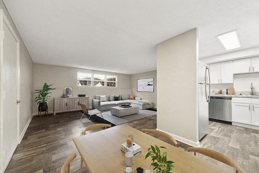 Model Dining Room with Wood-Style Flooring and View of Kitchen at Meadows at Marlborough Apartments located in Marlborough, MA.