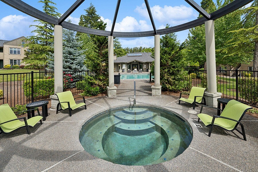 Community Hot Tub and Swimming Pool with Pool Furniture at The Club Apartments located in Hillsboro, OR.